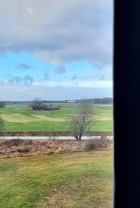 een uitzicht op een veld vanuit een treinraam bij Hotell Tre Systrar in Eskilstuna