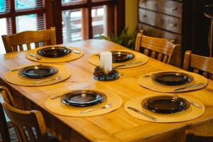 a wooden table with plates and a candle on it at Villa Natura - Private Villa by a Lake near Vratsa in Glavatsi