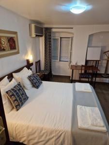 a bedroom with a large white bed with pillows at Residencial Antonio Mocisso Guesthouse in Elvas