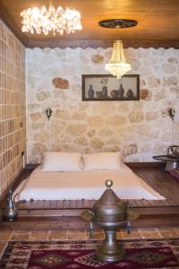 1 dormitorio con 1 cama en una pared de piedra en Likya Yolu Palas Hotel, en Kapaklı