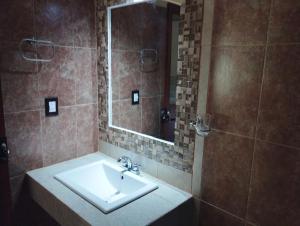 La salle de bains est pourvue d'un lavabo et d'un miroir. dans l'établissement Calli Sofi Posada, à Tepoztlán