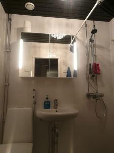 uma casa de banho com um lavatório e um espelho em Ylimmän kerroksen luksusnäkymät ydinkeskustassa em Uusikaupunki