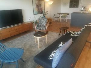 uma sala de estar com um sofá e cadeiras e uma televisão em Ylimmän kerroksen luksusnäkymät ydinkeskustassa em Uusikaupunki