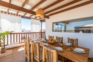 a dining room with a table and a balcony at Villa Samui in Playa Blanca