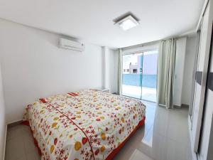 1 dormitorio con cama y ventana grande en Residencial Montblanc, en Bombinhas