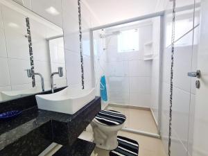 Baño blanco con lavabo y aseo en Residencial Montblanc, en Bombinhas