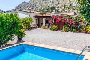 a house with a swimming pool and flowers at Villa Rosita in Pollença