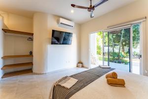 ein Schlafzimmer mit einem großen Bett und einem TV an der Wand in der Unterkunft Artec Studios in Tulum