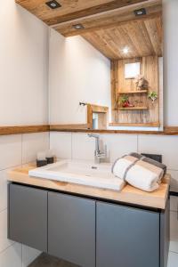 een badkamer met een wastafel en een houten plafond bij Chalet Schintlbauer in Annaberg im Lammertal