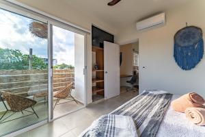 Schlafzimmer mit einem Bett und einer Glasschiebetür in der Unterkunft Artec Studios in Tulum