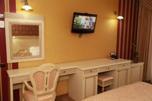 a room with a desk with a television and a chair at Hotel Majestic in Iaşi