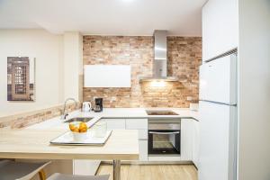 kuchnia z białymi szafkami i drewnianym blatem w obiekcie CartagenaFlats - Apartamentos Turísticos Jabonerías 16, CITY CENTER w mieście Cartagena
