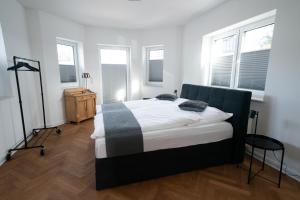 ein Schlafzimmer mit einem Bett in einem Zimmer mit Fenstern in der Unterkunft Villa Emma in Osnabrück