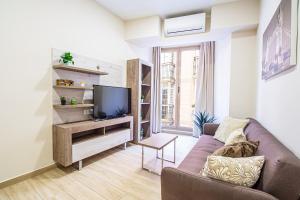 uma sala de estar com um sofá e uma televisão em CartagenaFlats - Apartamentos Turísticos Jabonerías 16, CITY CENTER em Cartagena