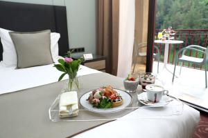 una mesa con un plato de comida en una cama en Best Western Plus Paradise Hotel Dilijan en Dilijan