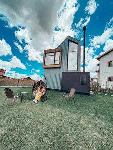 a tiny house sitting on top of a grass field at Tiny House Cambará in Cambara do Sul