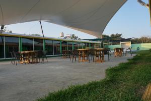 un groupe de tables et de chaises sous une tente dans l'établissement Velaria, à Chachalacas