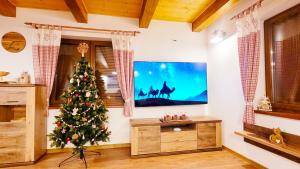 a living room with a christmas tree and a tv at chalupa Český štít Vysoké Tatry in Stará Lesná