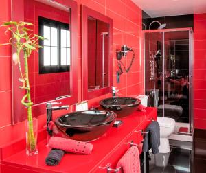 a red bathroom with two sinks on a red counter at Evita Beach Suites Exclusivas in Caleta de Sebo +146 photos