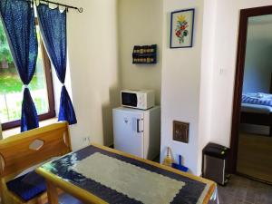 Zimmer mit einem Tisch und einer Mikrowelle auf einem Kühlschrank in der Unterkunft Zselic Szíve Parasztház in Simonfa