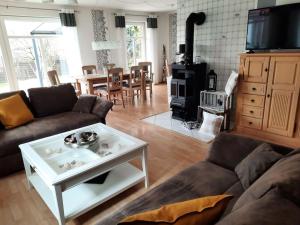 a living room with a couch and a wood stove at Urlaubsdomizil Norden/Norddeich, mit Garten in Norden