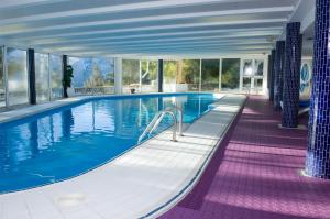 レ・デュー・アルプにあるMadame Vacances Hôtel Ibizaの窓のある建物にある大きなプール