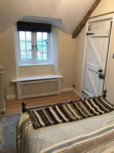 a bedroom with a bed and a window and a door at Hallgarden Farmhouse in Otterham