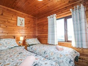 a bedroom with two beds in a log cabin at Holly Lodge in Saltburn-by-the-Sea