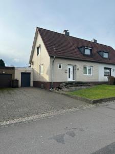 a white house with a garage and a driveway at Gerberstraße 41, 24537 Neumüster in Neumünster