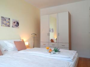 1 dormitorio con cama blanca y armario grande en Blankwasserweg 51, Whg 5 - Wohnung mit Strandkorb nur 5 Minuten zum Strand, en Grömitz