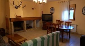 a living room with a table and a fireplace at Casas Rurales Fuenmayor in Torres