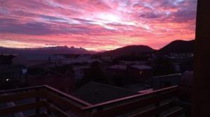 a view of a sunset from a balcony at Calido alojamiento in Ushuaia