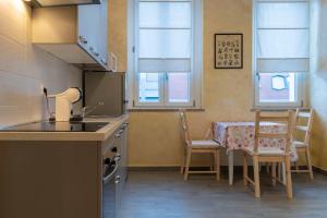 une cuisine avec un évier et une table avec des chaises dans l'établissement Leader Apartment 4, à Milan