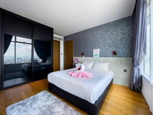 a bedroom with a bed with a pink dress on it at The Luxury Penthouses Kuala Lumpur in Kuala Lumpur