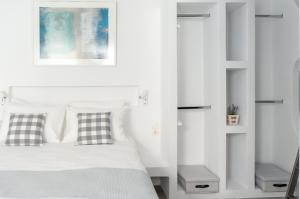 a bedroom with white walls and a bed with two pillows at Pelican Paros in Parikia