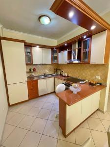 a kitchen with white cabinets and a wooden counter top at Superb Apt Central in Durrës