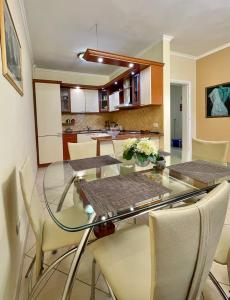 a dining room and kitchen with a glass table and chairs at Superb Apt Central in Durrës