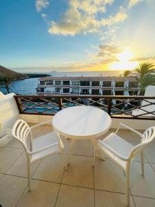 balcón con mesa, sillas y vistas al océano en Apartment with beautiful ocean view en Costa del Silencio