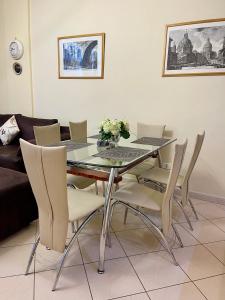 a dining room with a glass table and chairs at Superb Apt Central in Durrës