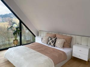 1 dormitorio con 1 cama grande y ventana grande en Black Diamonds Hill en Istebna