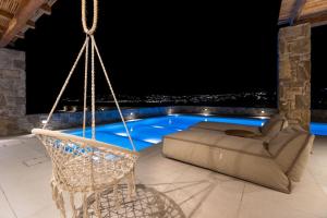 un patio con altalena e una piscina di notte di Villa Myko by Bestofmikonos a Mykonos Città