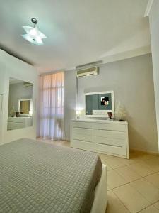 a bedroom with a bed and a flat screen tv at Superb Apt Central in Durrës