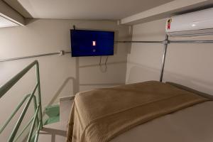 a hospital room with a bed and a tv on the wall at Casa Savana in São Paulo
