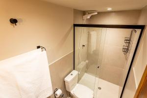 a bathroom with a white toilet and a shower at Casa Savana in São Paulo