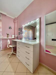 a bathroom with a vanity with a mirror and a chair at Superb Apt Central in Durrës