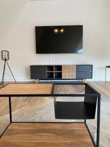 a living room with a tv and a glass table at Ferienwohnung Haus Ossenkopp in Dümmer