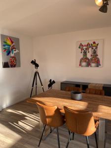 a dining room with a wooden table and a camera at Ferienwohnung Haus Ossenkopp in Dümmer