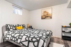 a bedroom with a black and white bed and a window at Cozy nest basement unit in Hamilton