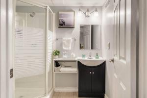 a white bathroom with a sink and a mirror at Cozy nest basement unit in Hamilton