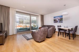 布德瓦Budvariana Apartments的一间带桌椅的客厅和一间用餐室